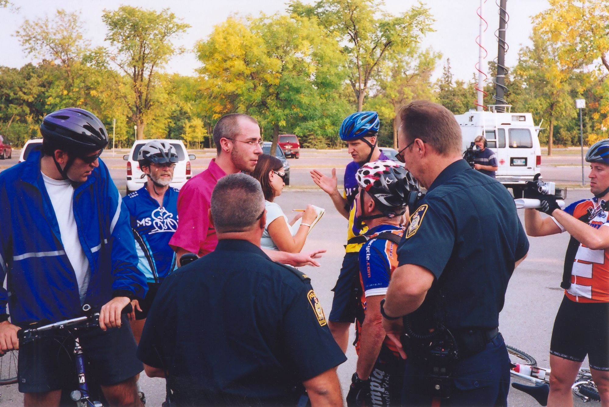 A photo of variously-facing people in cyclist gear and two police officers