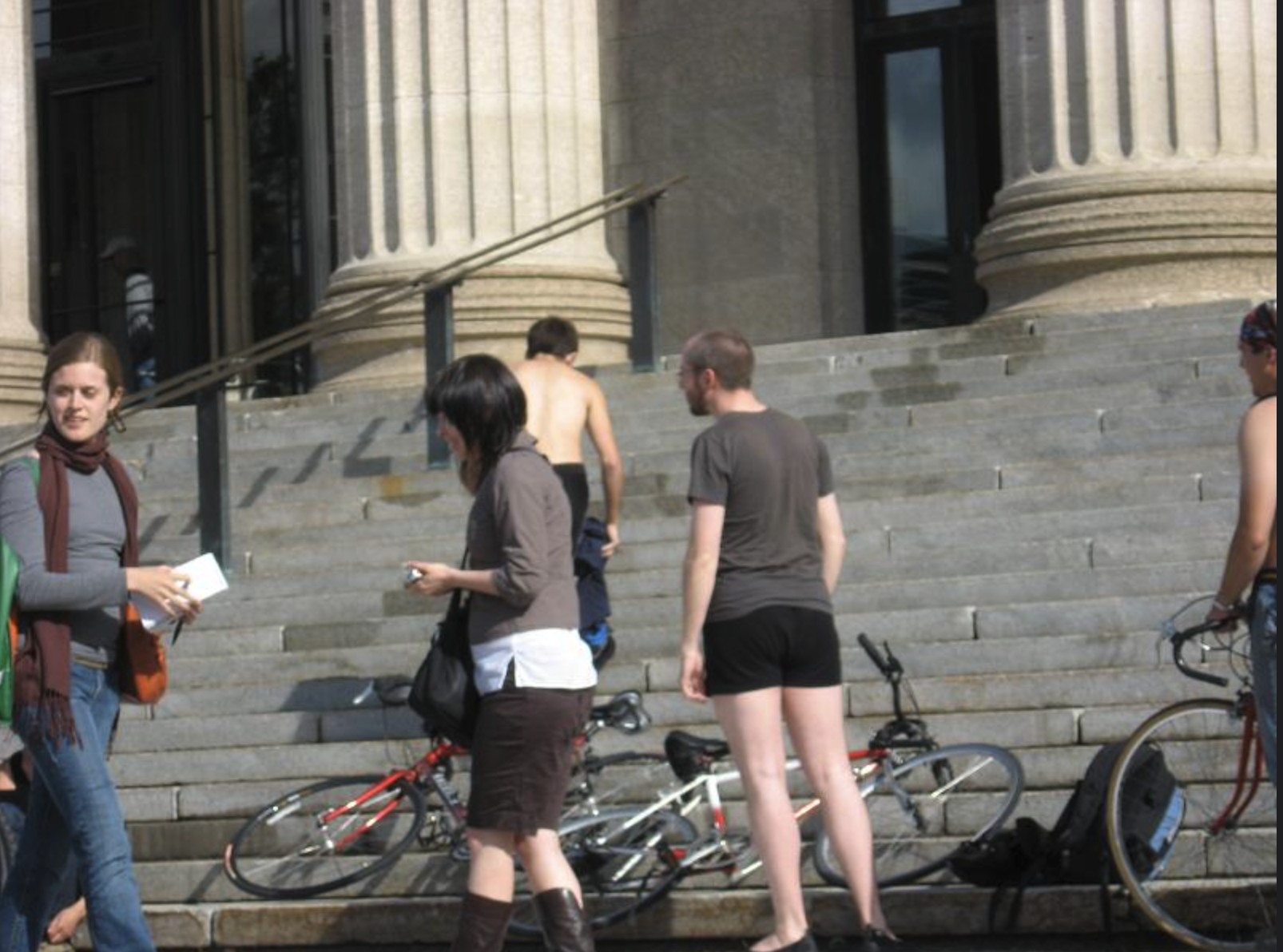 A photo of people in front of the steps of the Manitoba Legislative Building, with bikes laid on the steps