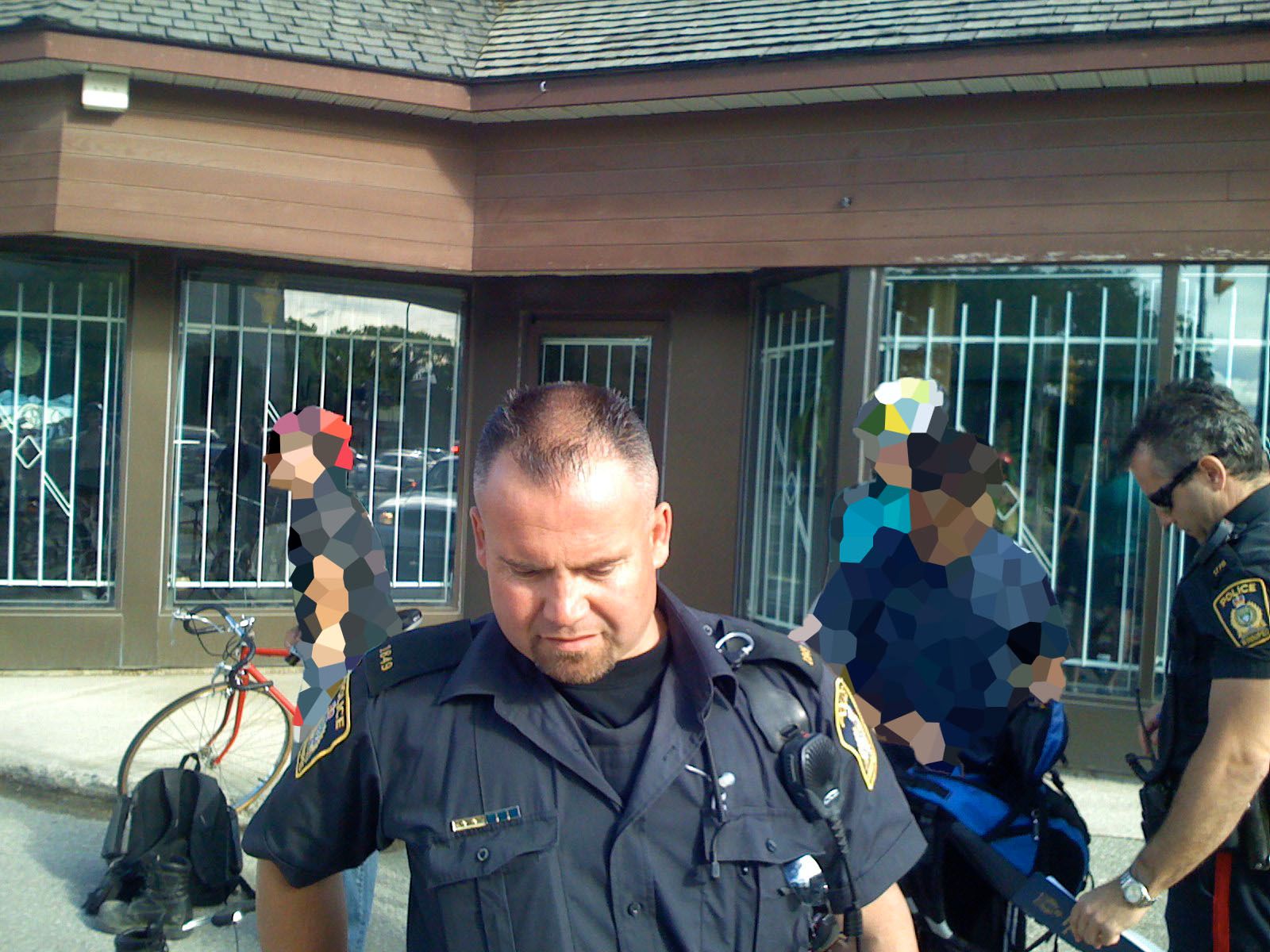 A photo of a semi-balding police officer facing the camera with his head tilted slightly downward